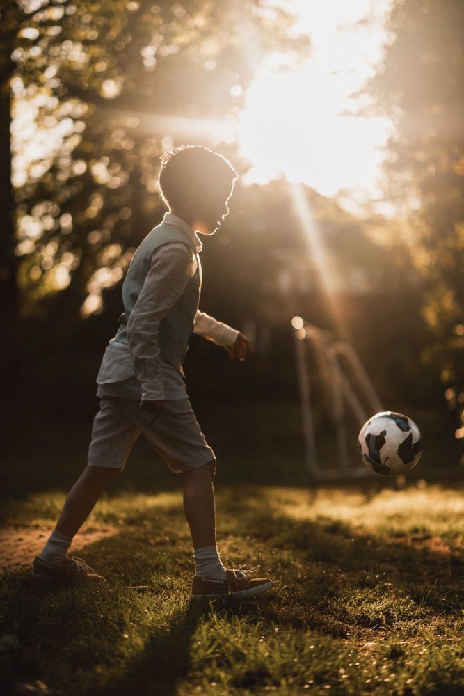 Jongen met voetbal in de zon